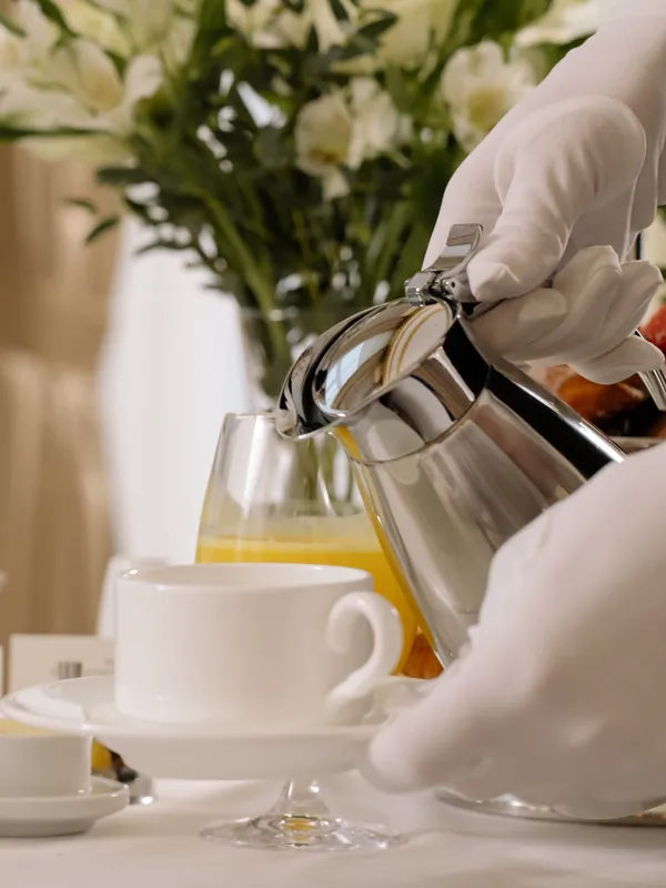 Majordome en gants blancs servant le petit-déjeuner