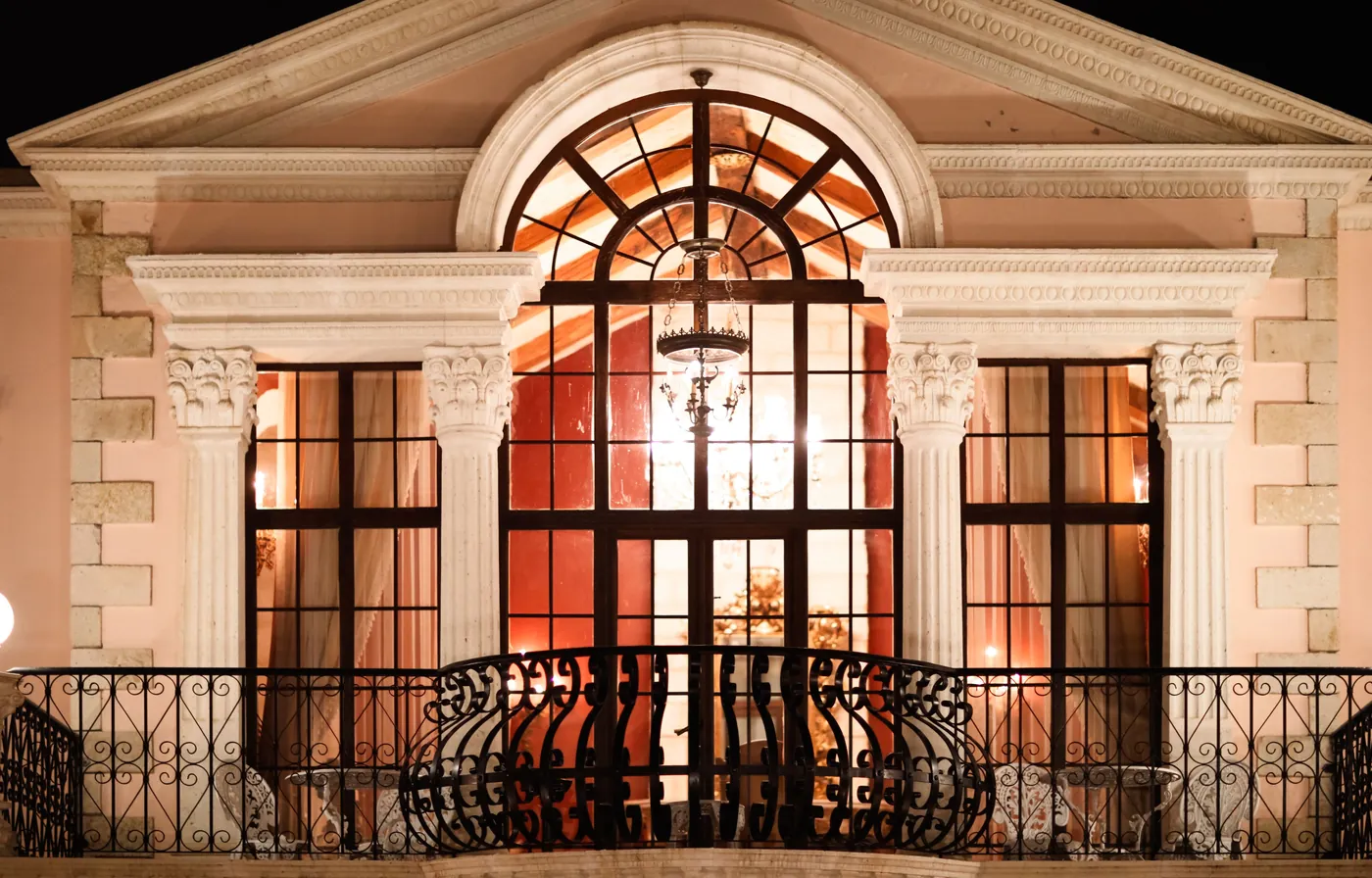 Façade néoclassique et son balcon illuminés, de nuit